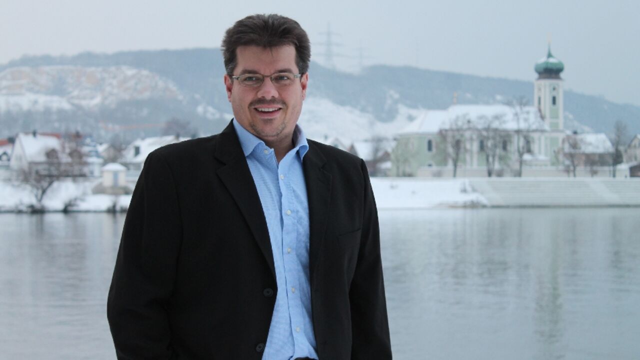 Ortsvorsitzender Christian Poh mit Schwabelweis im Winter im Hintergrund