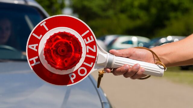 Polizei: Polizeikontrolle Polizeikontrolle mit Halt Polizei-Schild im Vordergrund