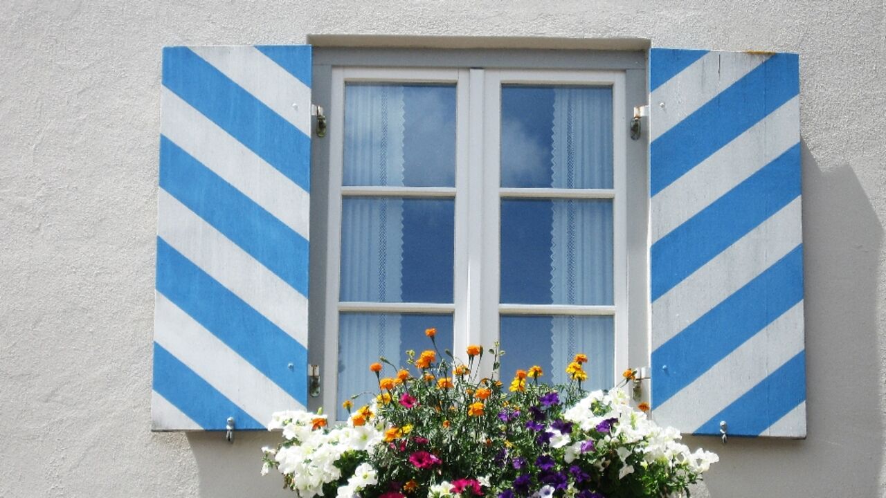 Fenster mit weiß-blauem Fensterladen