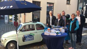Ein Auto, Ein Sonnenschirm, Personen an einem Infotisch
